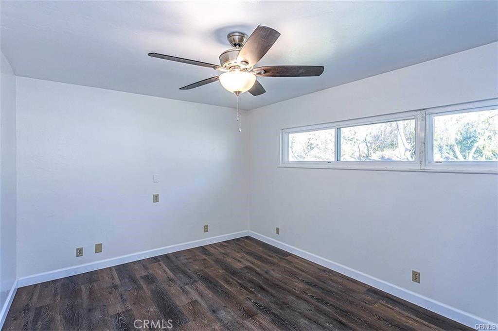 3454 Spruce Street Riverside, CA 92501 - Photo 5 of 6 an empty room with wooden floor fan and windows