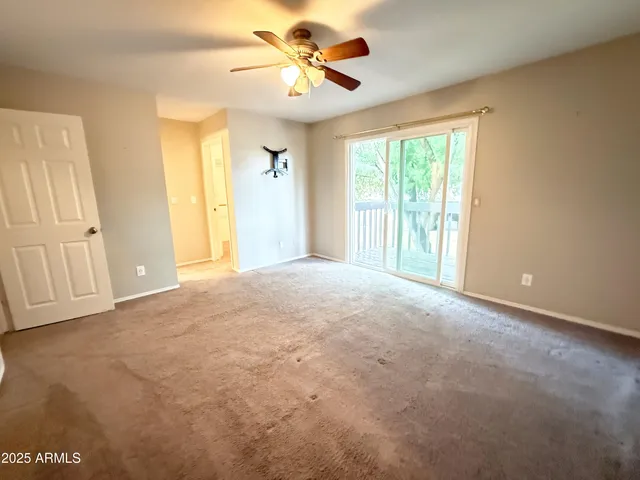 a view of a livingroom with a chandelier fan and windows