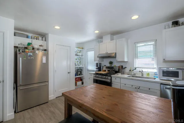 a kitchen with stainless steel appliances granite countertop a stove a sink dishwasher and a stove with wooden floor