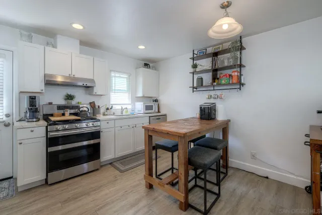 a kitchen with kitchen island granite countertop a refrigerator stove microwave and cabinets