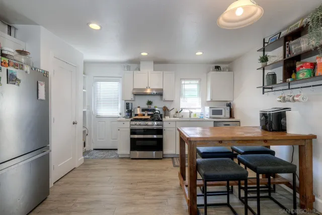 a patio with a table and chairs and potted plants