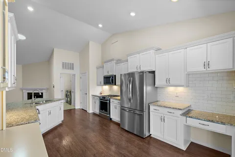 a kitchen with a window a sink and wooden floor