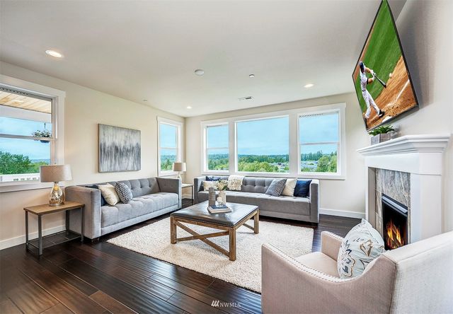 a living room with furniture a fireplace and a large window