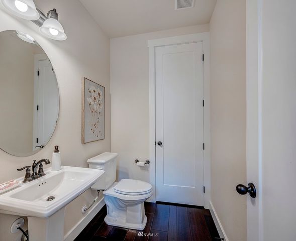 a bathroom with a toilet sink a mirror and vanity