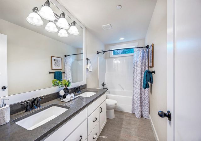 a spacious bathroom with a double vanity sink mirror and double