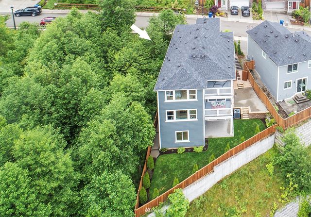 an aerial view of a house with a yard and a large tree