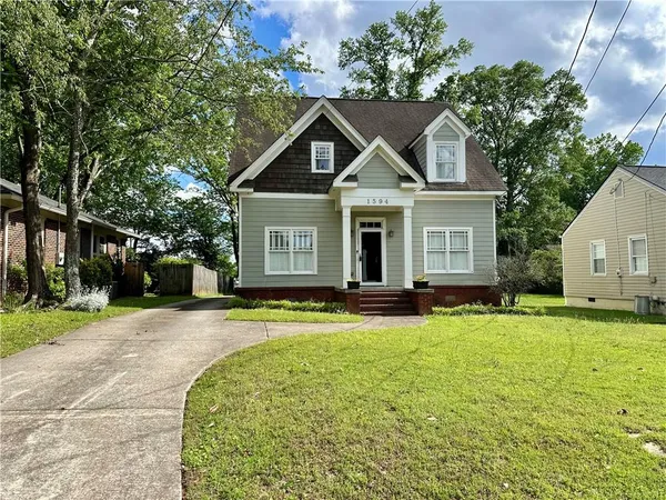 a front view of a house with yard and green space