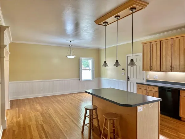 a kitchen with a table chairs and wooden floor