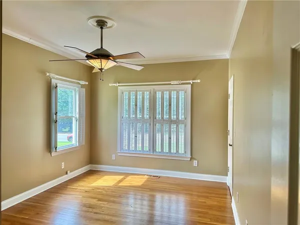 a view of an empty room with window and wooden floor
