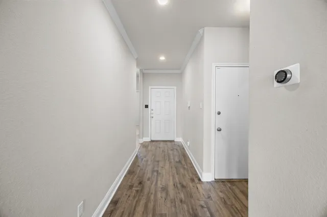 a view of a hallway with wooden floor