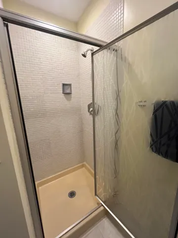 a bathroom with a shower and a glass door