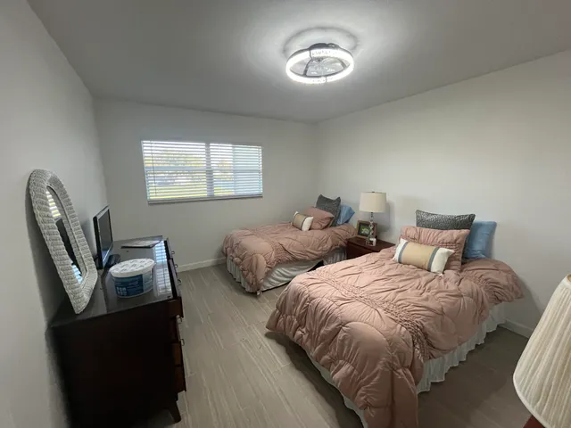 a bedroom with two beds and a chair
