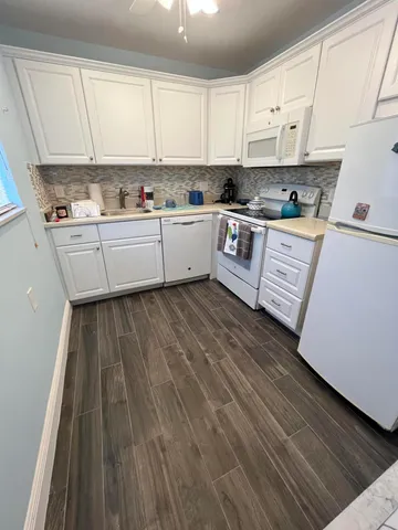a kitchen with wooden floors sink and cabinets