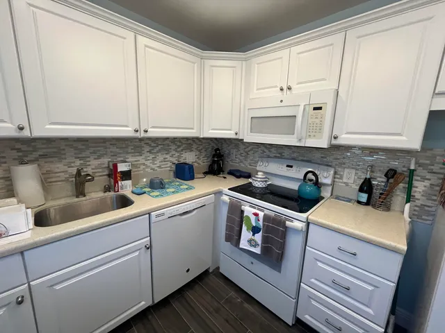 a kitchen with stainless steel appliances granite countertop a sink a stove and cabinets