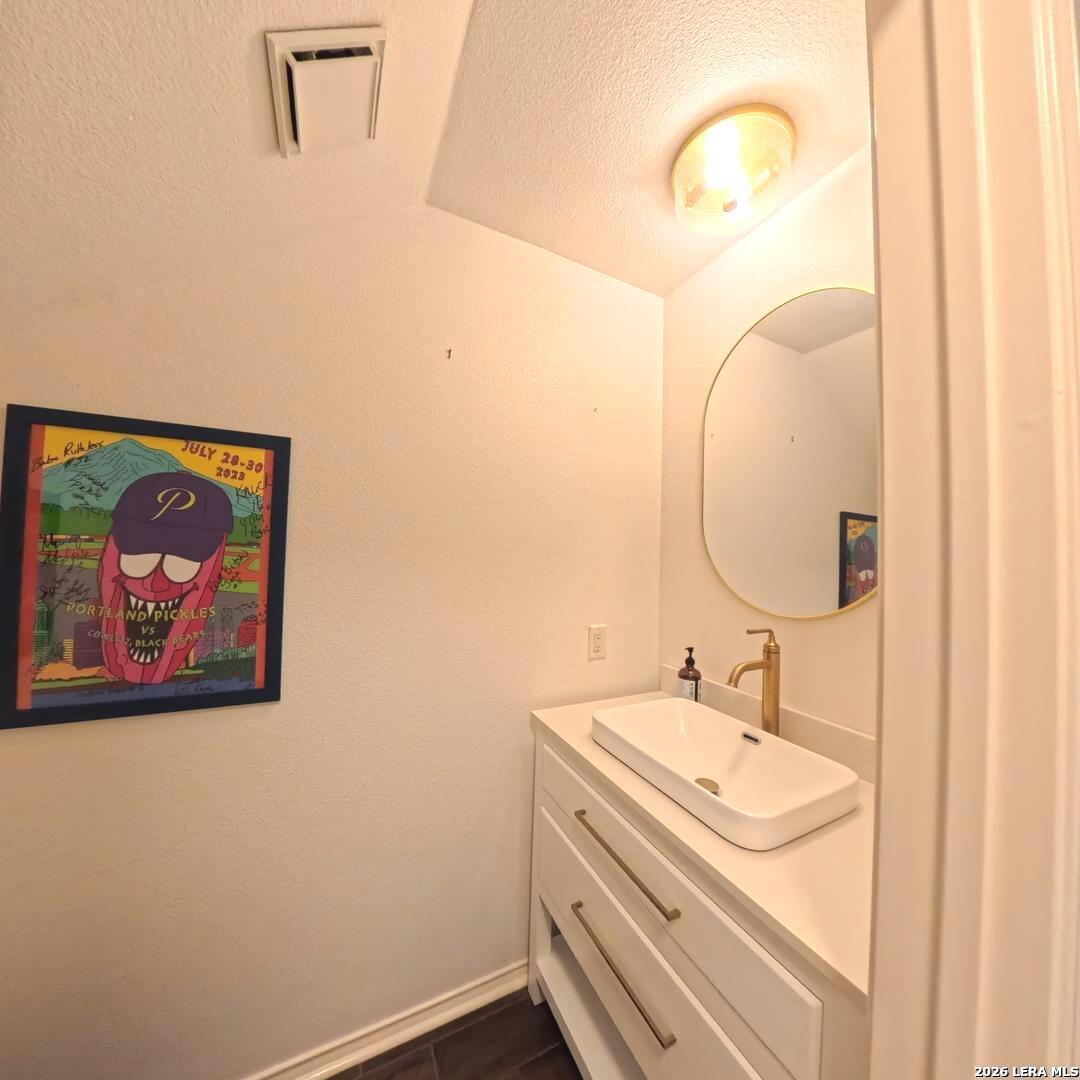 20115 Standish Road San Antonio, TX 78258 - Photo 17 of 51 a bathroom with a sink and a mirror