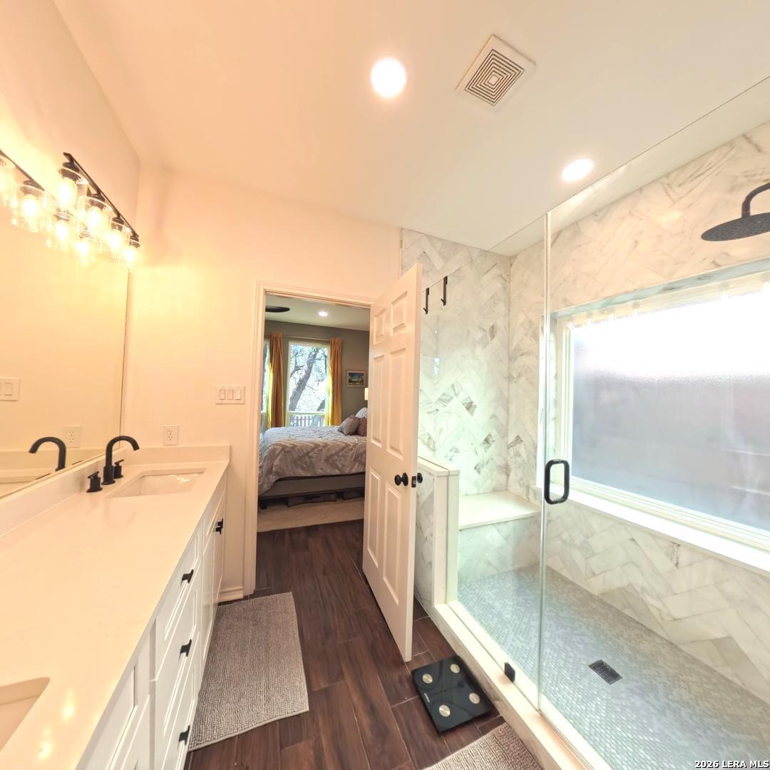20115 Standish Road San Antonio, TX 78258 - Photo 23 of 51 a spacious bathroom with a shower sink and mirror