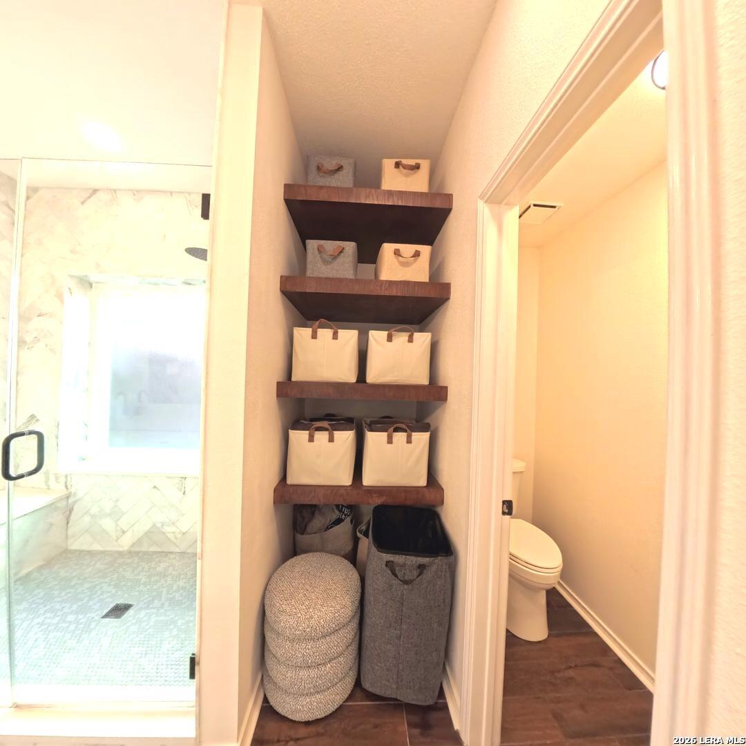 20115 Standish Road San Antonio, TX 78258 - Photo 26 of 51 a bathroom with a granite countertop toilet a sink and a mirror