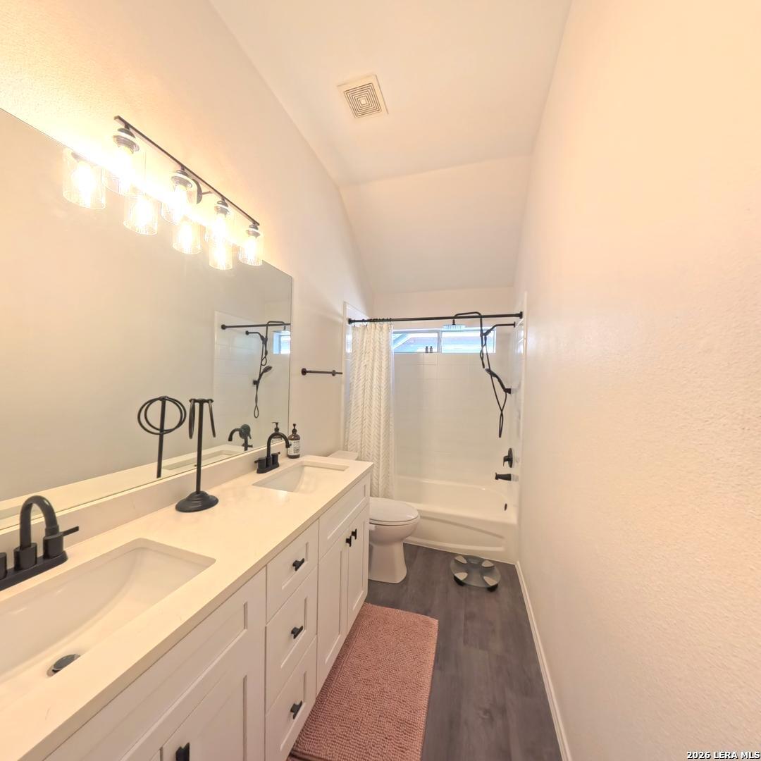 20115 Standish Road San Antonio, TX 78258 - Photo 39 of 51 a bathroom with a double vanity sink a mirror and a shower