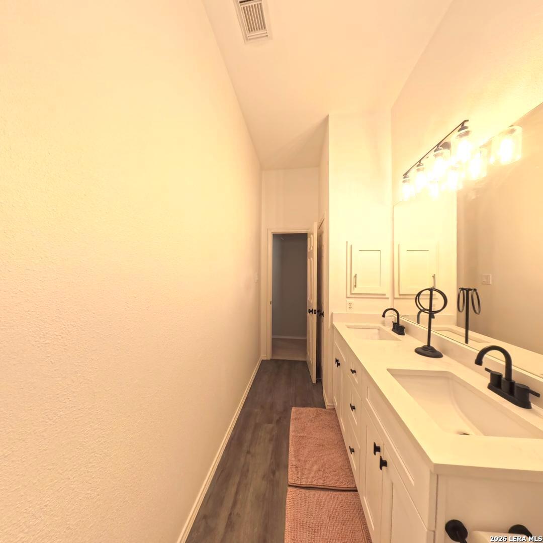 20115 Standish Road San Antonio, TX 78258 - Photo 40 of 51 a bathroom with a double vanity sink and mirror