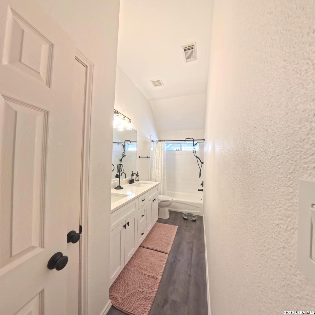 20115 Standish Road San Antonio, TX 78258 - Photo 41 of 51 a bathroom with a double vanity sink toilet mirror and shower