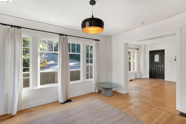 a view of an entryway with a floor to ceiling window and wooden floor