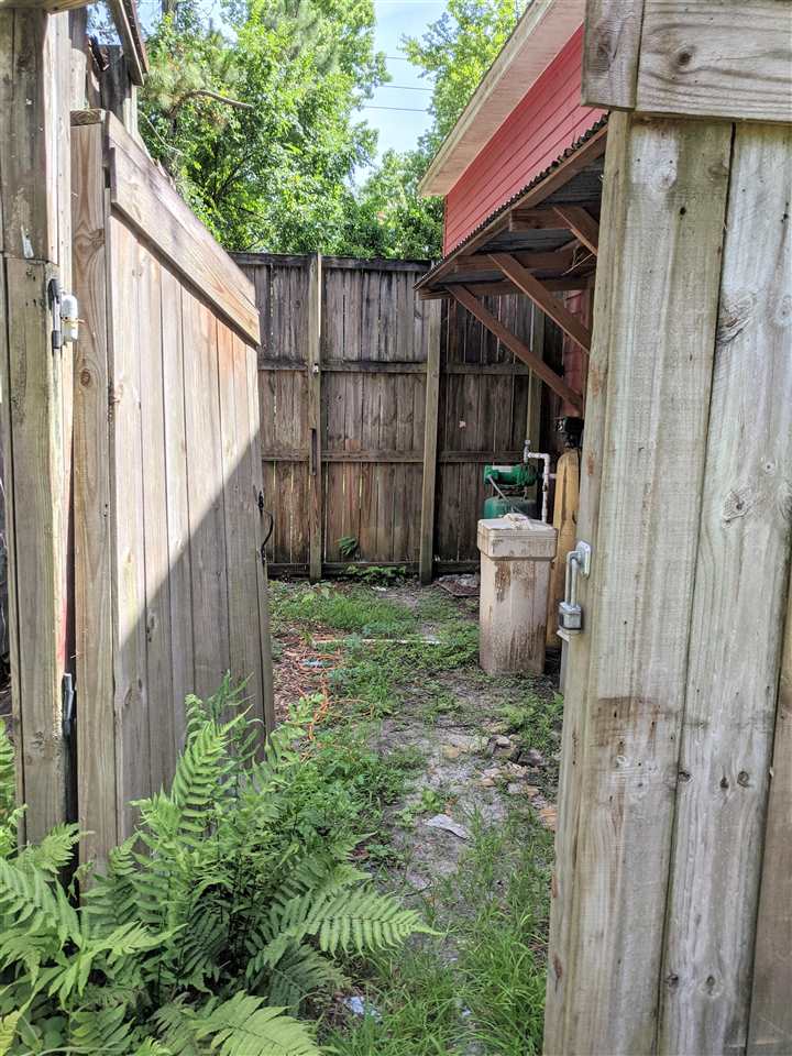1340 Kings Estate Road St. Augustine, FL 32086 - Photo 4 of 40 a view of a backyard with small cabin and wooden fencing
