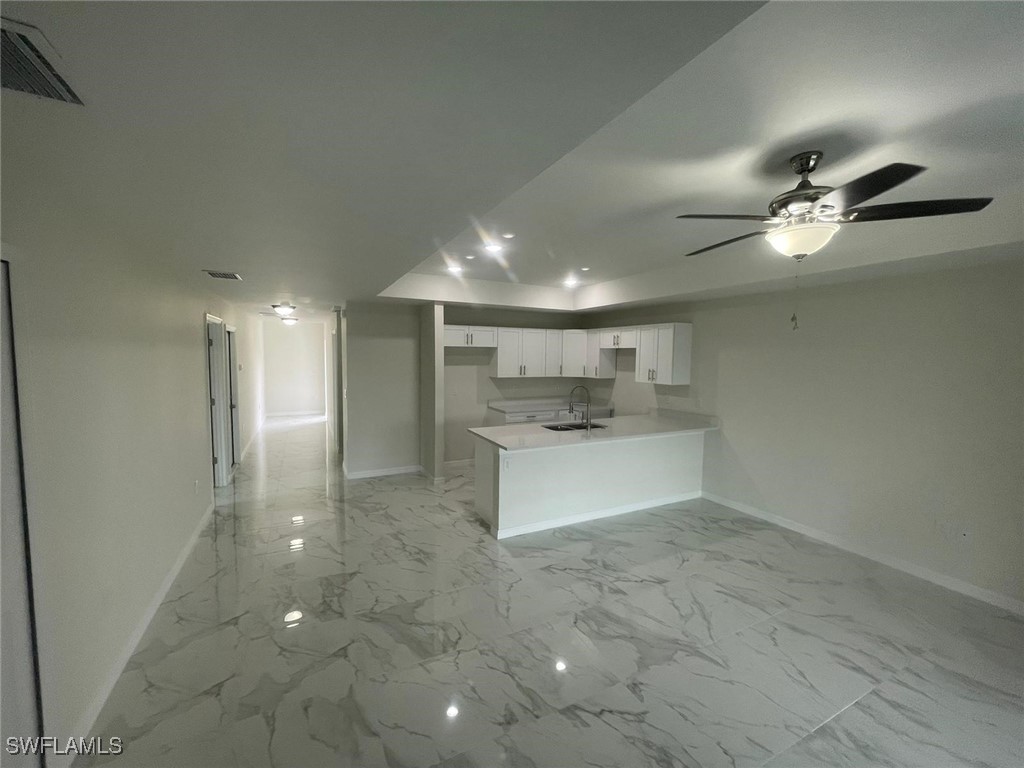 4524-4526 15th Street Southwest Lehigh Acres, FL 33973 - Photo 3 of 27 a view of a kitchen with a sink and a refrigerator
