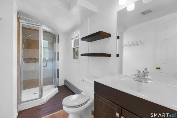 a bathroom with a sink a toilet and shower