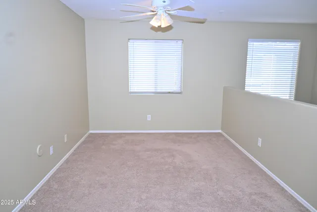 a view of an empty room with window and cabinet