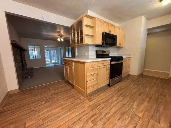 a kitchen with stainless steel appliances granite countertop a stove top oven a sink with wooden floors
