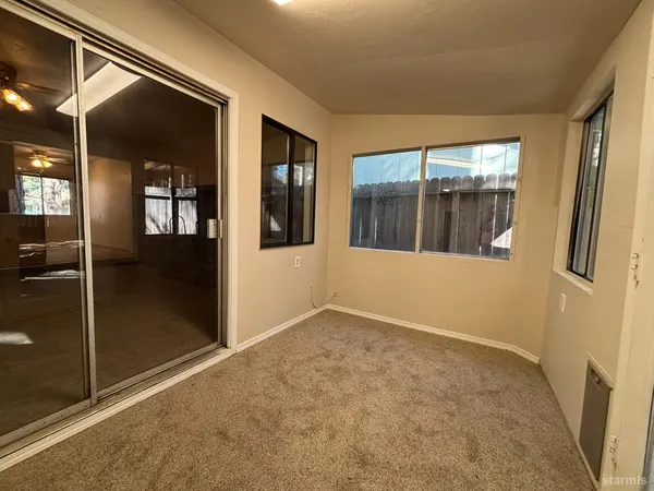 a view of a hallway with a glass door and furniture