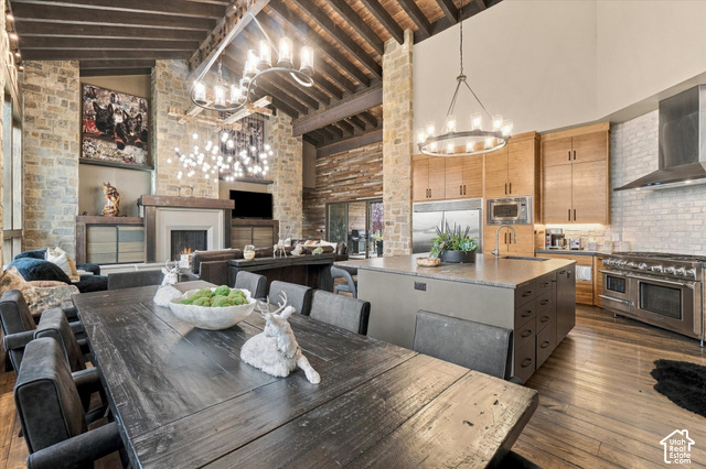 5936 Triple Crown Trail Oakley, UT 84055 - Photo 13 of 57 Vaulted exposed beam ceiling, stone accent walls, integrated fireplace, expansive kitchen island, and stainless steel appliances