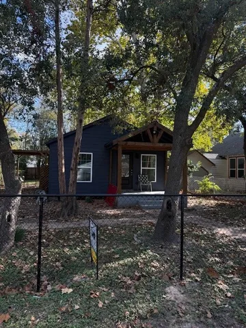 a view of a house with a yard and large tree