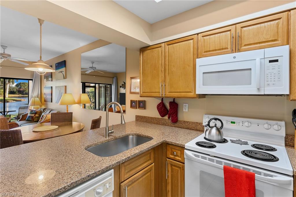 3324 Olympic Drive, Unit 313 Naples, FL 34105 - Photo 14 of 43 a kitchen with a sink stove and cabinets
