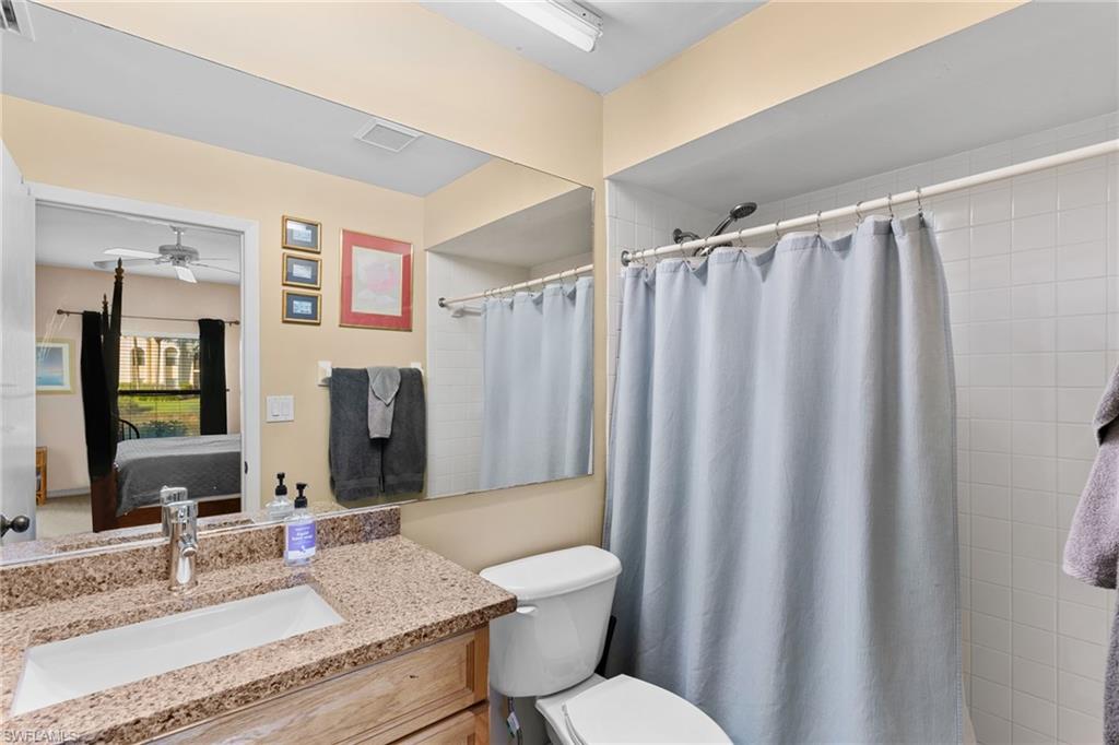 3324 Olympic Drive, Unit 313 Naples, FL 34105 - Photo 18 of 43 a bathroom with a granite countertop sink toilet and shower