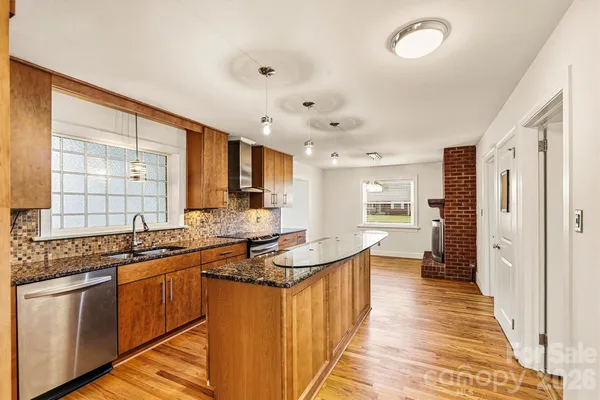a kitchen with stainless steel appliances granite countertop a sink stove and cabinets