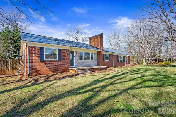 a view of a house with backyard and trees