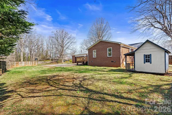 a view of a yard in front of a house with a large tree