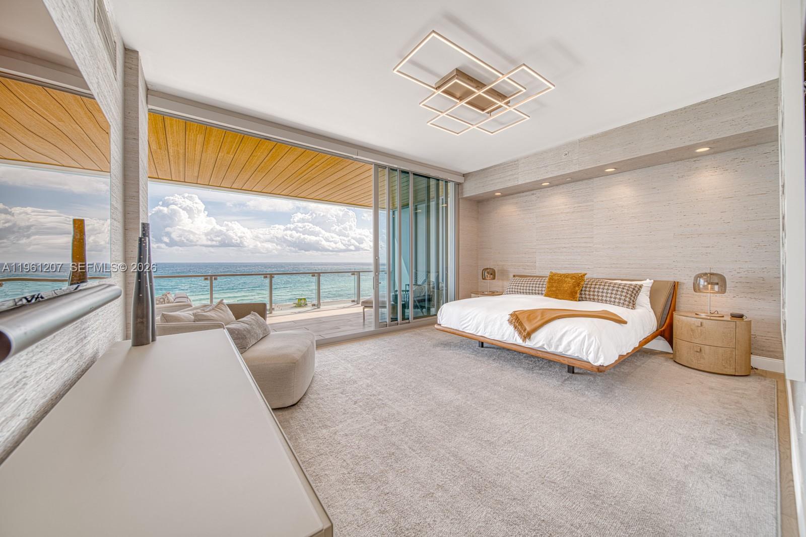 5775 Collins Avenue, Unit 703 Miami Beach, FL 33140 - Photo 21 of 44 a spacious bedroom with a bed and large windows