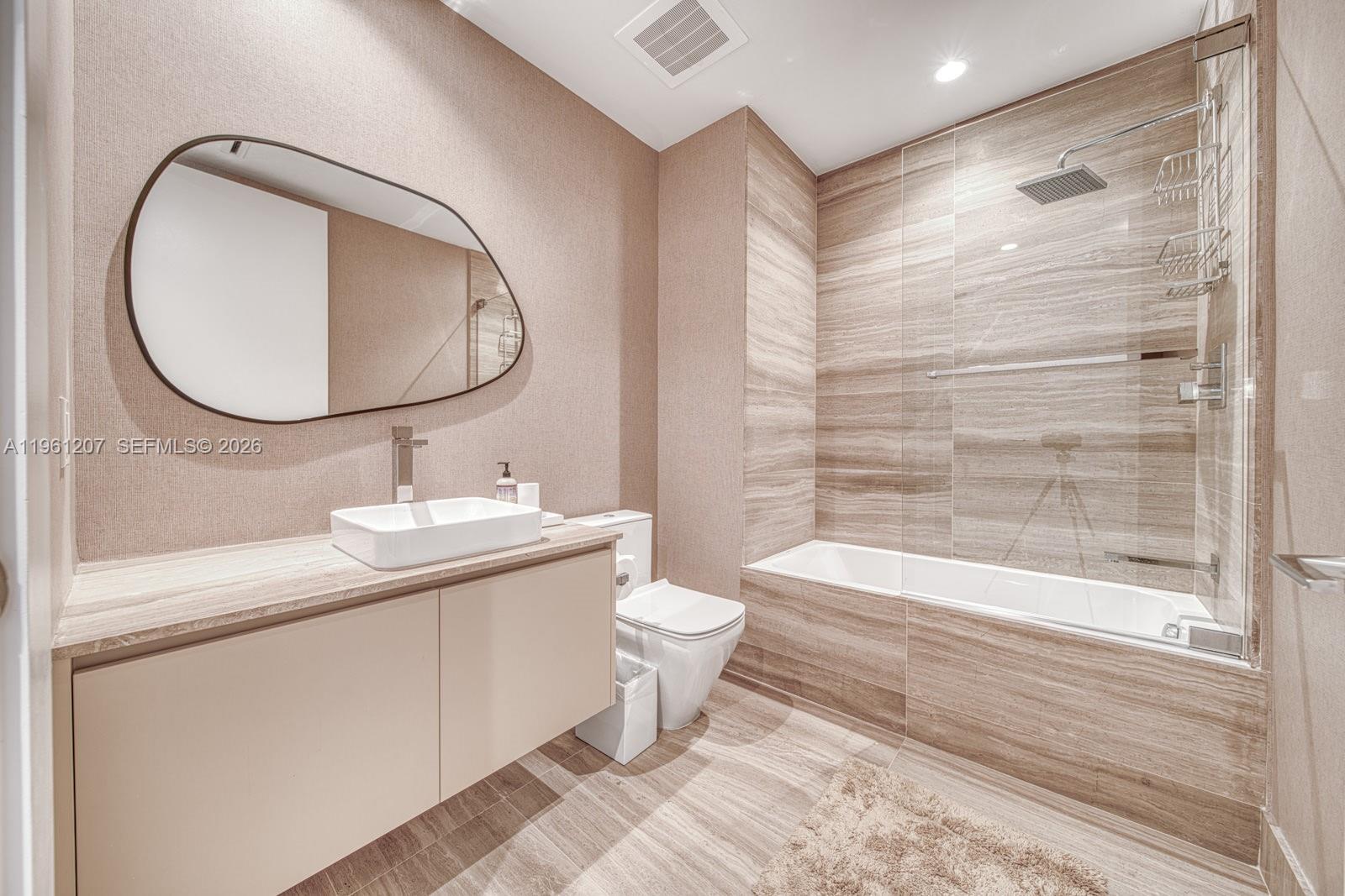 5775 Collins Avenue, Unit 703 Miami Beach, FL 33140 - Photo 34 of 44 a bathroom with a toilet a sink and a mirror