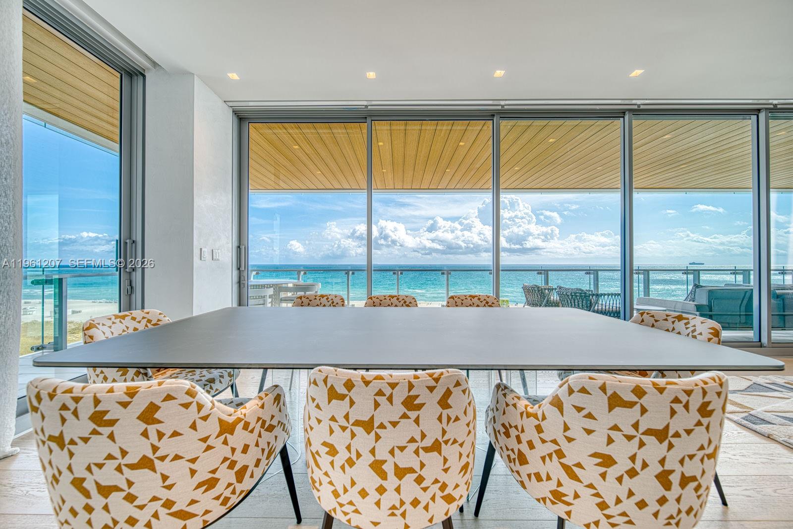 5775 Collins Avenue, Unit 703 Miami Beach, FL 33140 - Photo 4 of 44 a blue room with large windows and a table