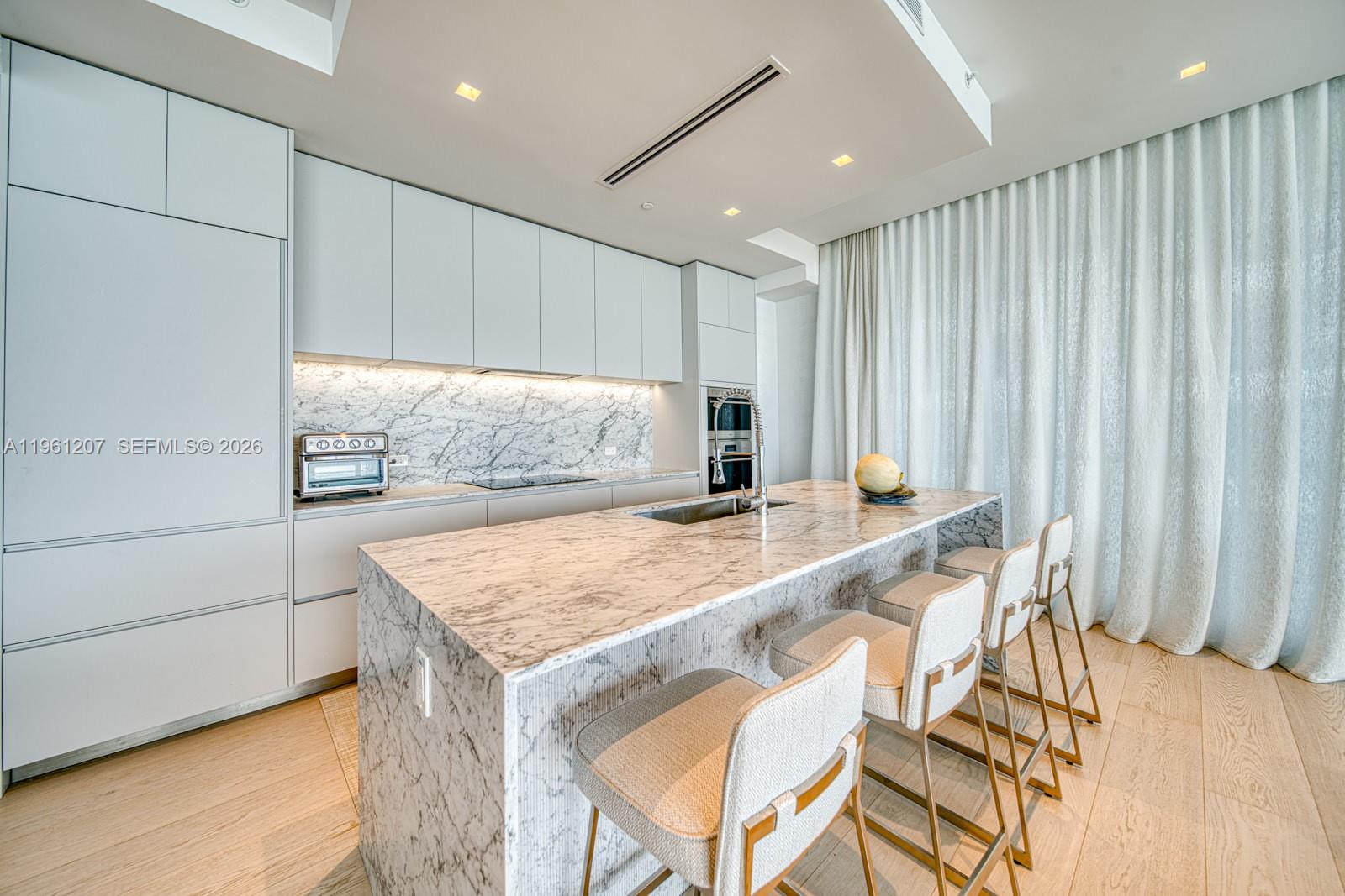 5775 Collins Avenue, Unit 703 Miami Beach, FL 33140 - Photo 5 of 44 a room with a table and chairs