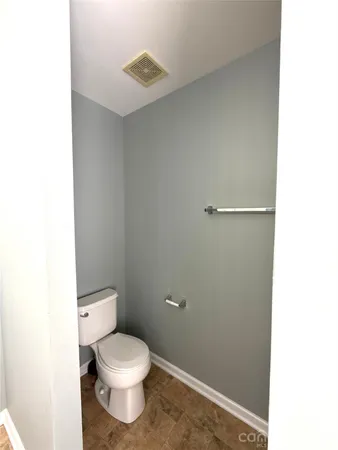 a white toilet sitting next to a white wall