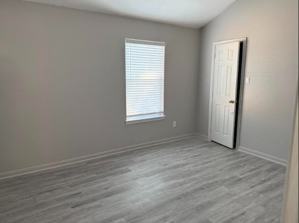 5637 Lotus Street Houston, TX 77085 - Photo 9 of 14 an empty room with wooden floor and windows