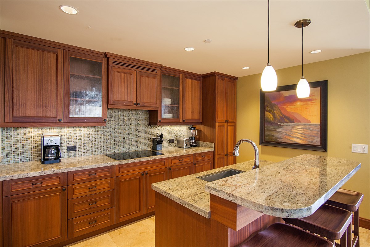 2641 Poipu Road, Unit 1401 Koloa, HI 96756 - Photo 2 of 12 a kitchen with stainless steel appliances granite countertop wooden cabinets a sink and dishwasher