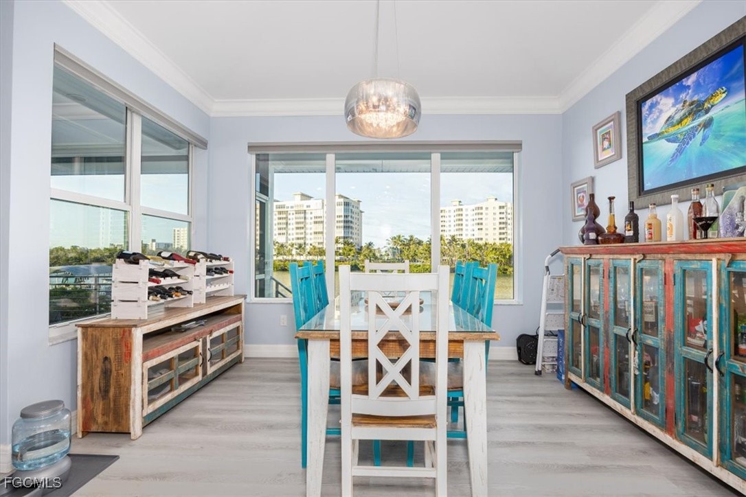 8425 Lagoon Road Fort Myers Beach, FL 33931 - Photo 16 of 49 a view of a dining room with furniture a chandelier and wooden floor
