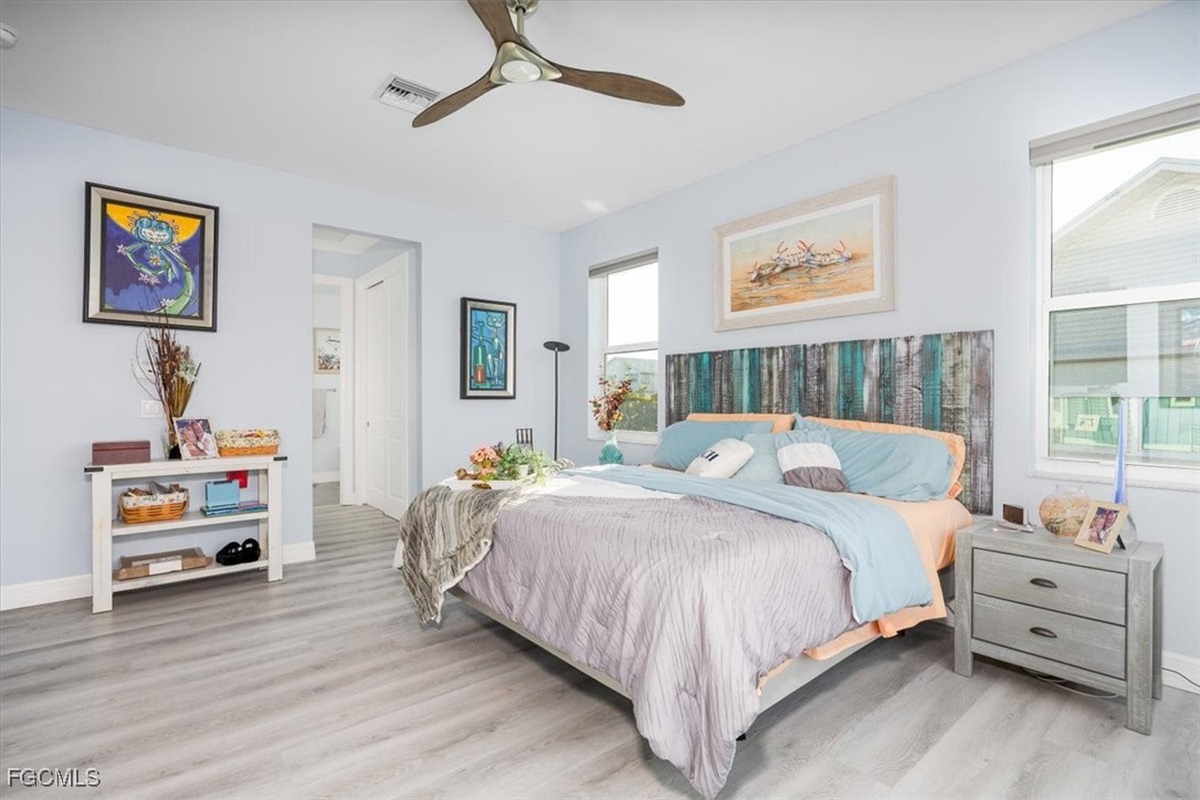 8425 Lagoon Road Fort Myers Beach, FL 33931 - Photo 25 of 49 a bedroom with a bed and wooden floor