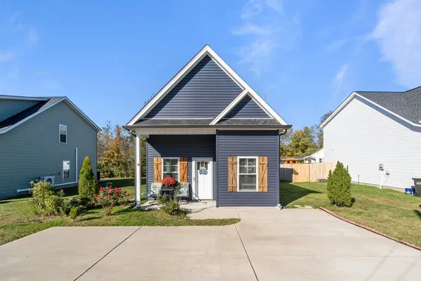 a front view of a house with a yard and potted plants