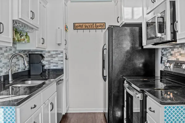 a kitchen with stainless steel appliances granite countertop a sink stove and refrigerator