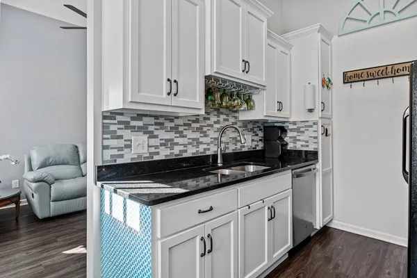 a kitchen with white cabinets and a refrigerator